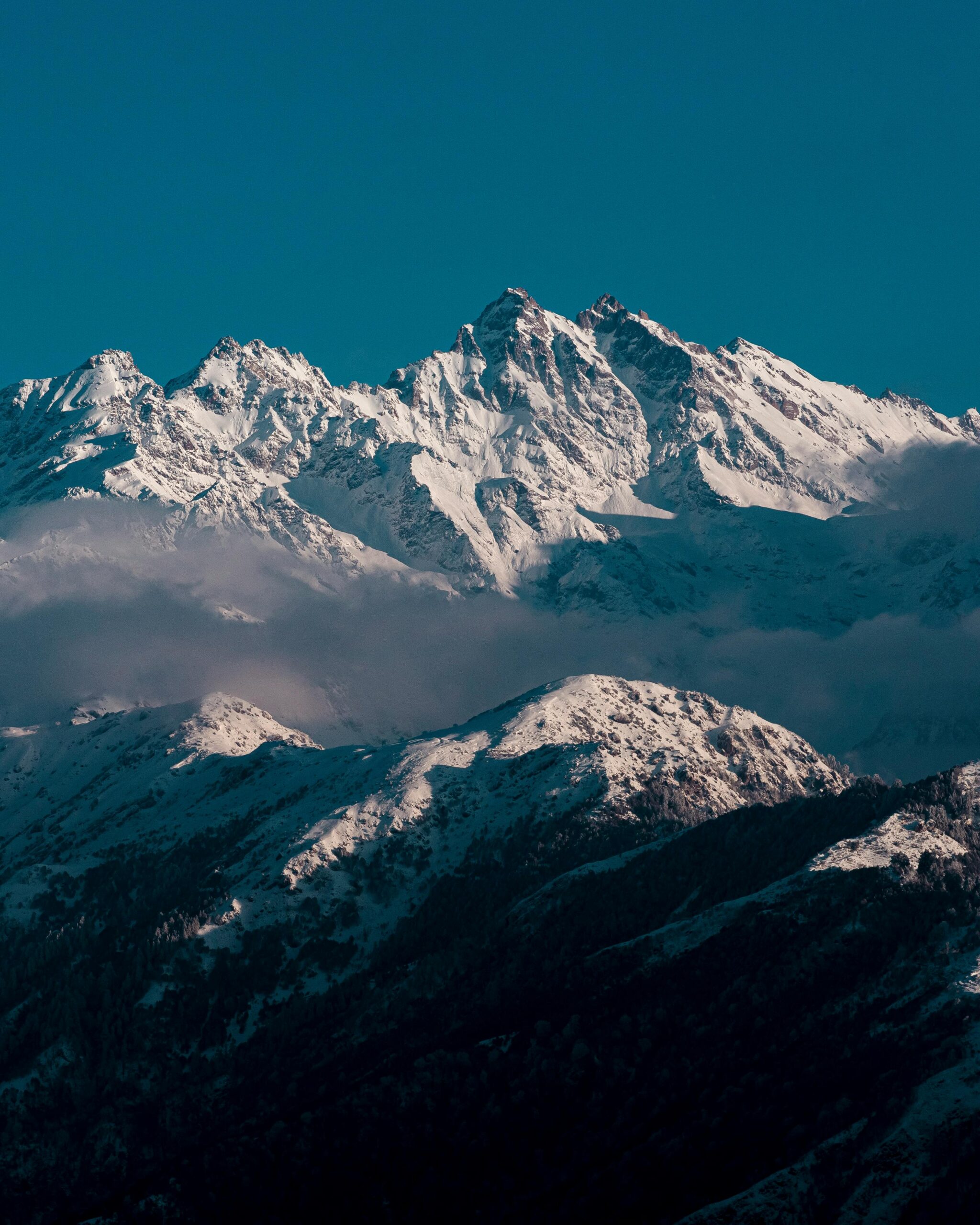Stunning view of snow-covered Himalayan peaks under a clear blue sky, perfect for adventure and nature themes.