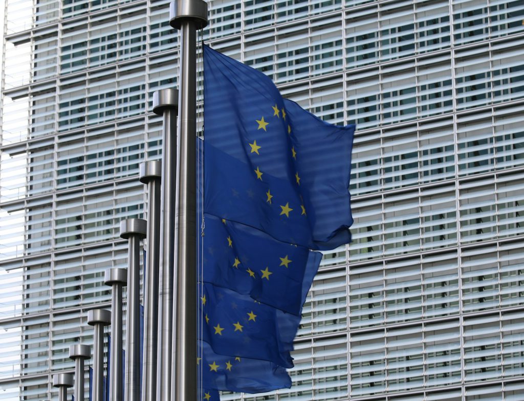 EU AI Act for software teams: provider or deployer? 2 European Union flags outside the Berlaymont building in Brussels